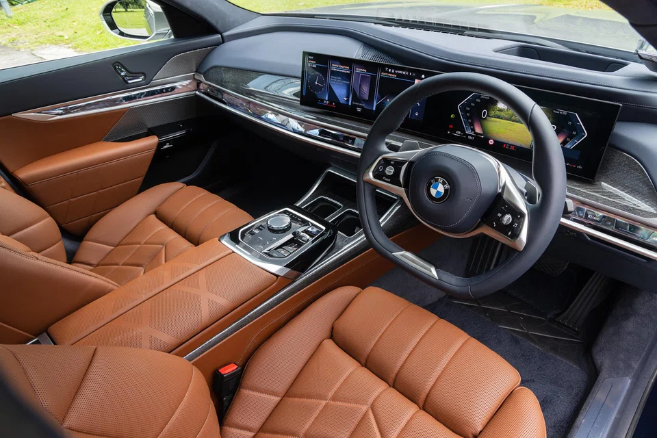 A freestanding curved display dominates the dashboard of the BMW 735i.