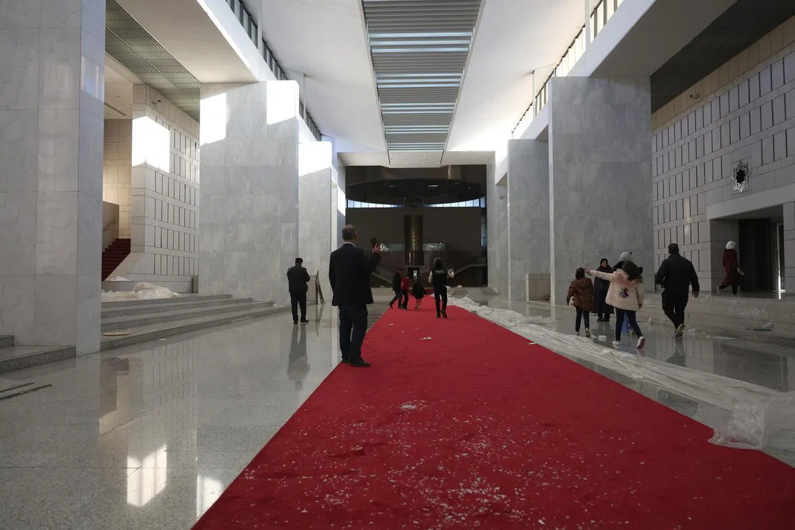 People walk inside the presidential palace after Syrian rebels took over Damascus, Syria, Dec 8, 2024. 