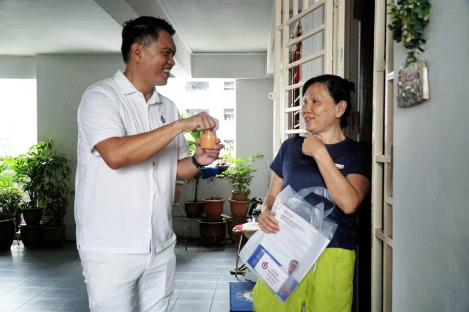 Patrick Tay (left), PAP's candidate for Pioneer SMC, with a resident on Apr 24.