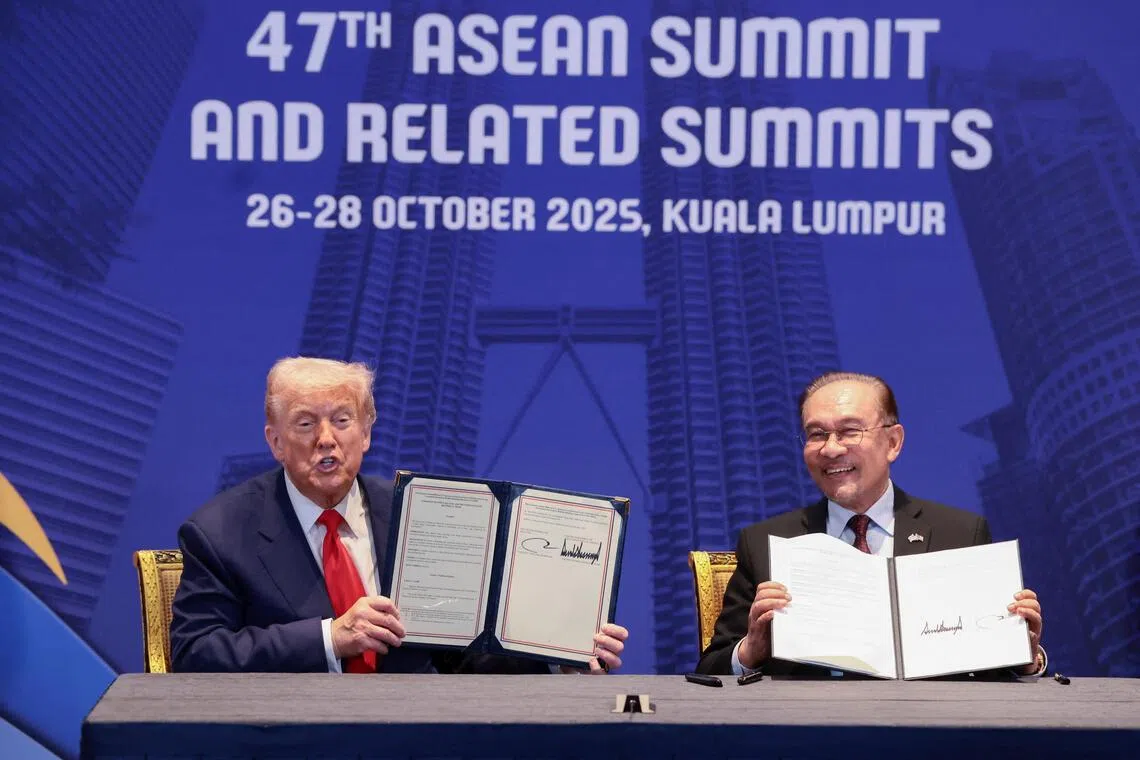 U.S. President Donald Trump and Malaysian Prime Minister Anwar Ibrahim hold up trade deal documents during a bilateral meeting during the 47th Association of Southeast Asian Nations (ASEAN) summit in Kuala Lumpur, Malaysia, October 26, 2025. REUTERS/Evelyn Hockstein