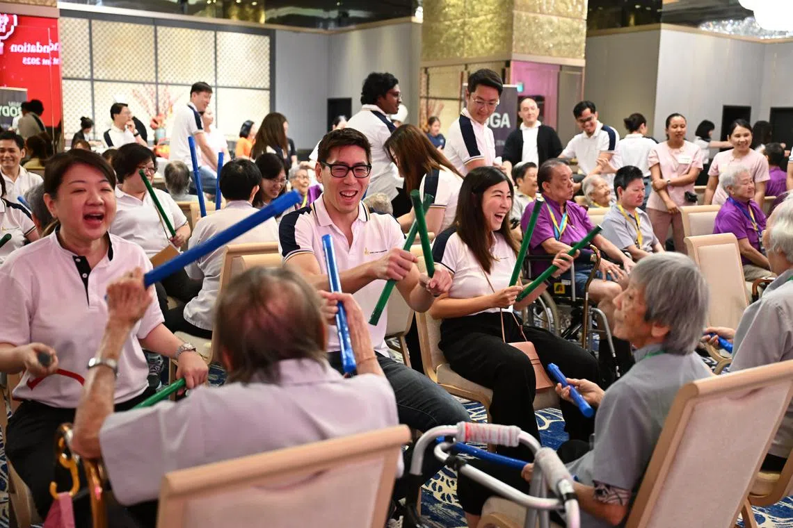 Hong Leong Foundation governors Quek Kon Hui (second from left) and Michelle Kwek (third from left) playing rhythmic games with senior beneficiaries at Silver Dance Fiesta.