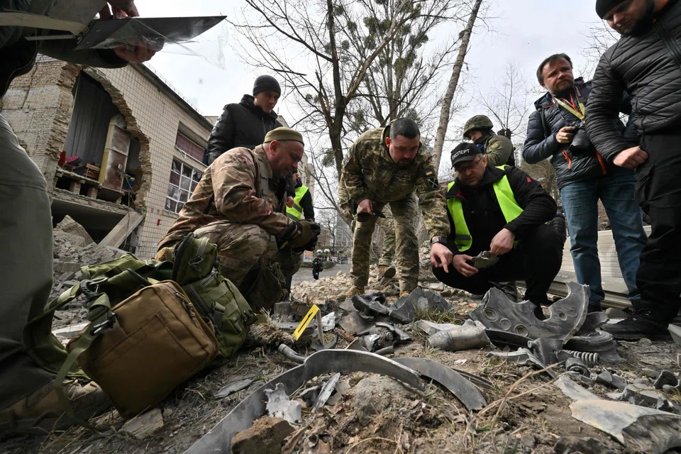 Ukrainian law enforcement officers examine fragments of a rocket at the site of a missile attack in Kyiv on Mar 25, 2024. A US official says Chinese companies are providing critical components for Russian military systems. 