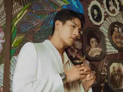 Sng wears a peach shirt and off-white suit by Celine, as well as a  B.Zero1 pendant chain necklace, B.Zero1 rings, B.Zero1 bangle and Octo Finissimo Chronograph GMT watch, all by Bulgari.