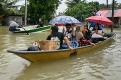 Residents being transported on boats through flood waters after days of heavy rain in Tumpat in Malaysia's Kelantan state last November.  