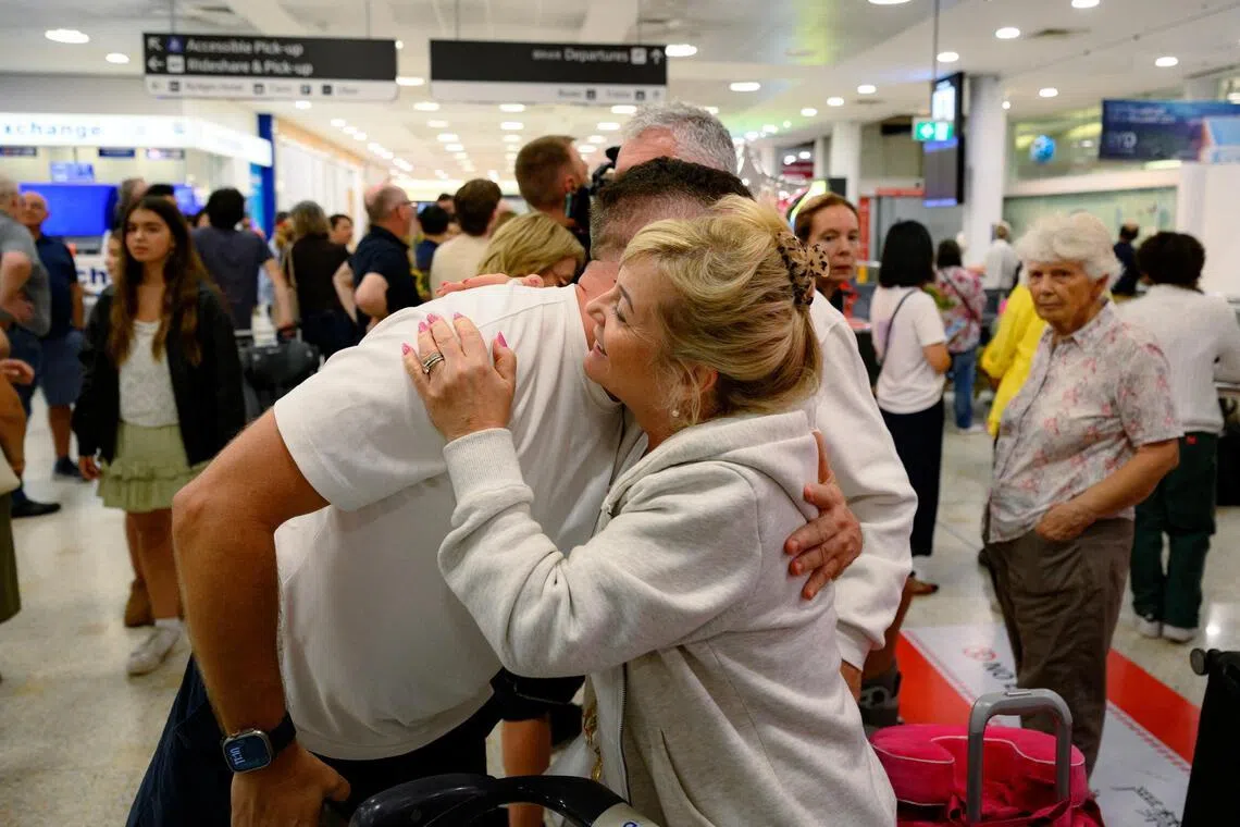 A passenger reacts after arriving from Dubai on a flight at Sydney international airport, Mascot, Australia, March 4, 2026. 