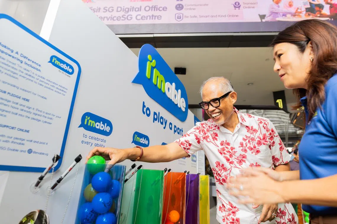 Minister for Social and Family Development Masagos Zulkifli with an SG Enable staff member at Volunteer Festival 2024 on Sunday.