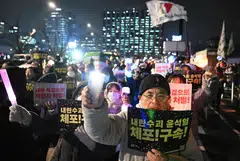 Protesters wave placards reading "Arrest Insurrectionist Yoon Suk Yeol" during a rally in Seoul, South Korea, Dec 16, 2024.