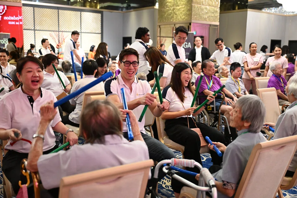 Hong Leong Foundation governors Quek Kon Hui (second from left) and Michelle Kwek (third from left) playing rhythmic games with senior beneficiaries at Silver Dance Fiesta.