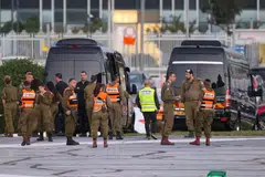 Israeli security forces stand next to buses waiting at the helipad of Tel Aviv's Schneider medical centre, amid preparations for the release of Israeli hostages held by Hamas in Gaza.
