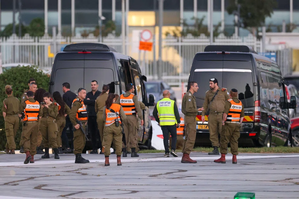 Israeli security forces stand next to buses waiting at the helipad of Tel Aviv's Schneider medical centre, amid preparations for the release of Israeli hostages held by Hamas in Gaza.