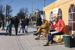 Customers outside a temporary cafe in Market Square in Helsinki, Finland, April 3, 2023. 