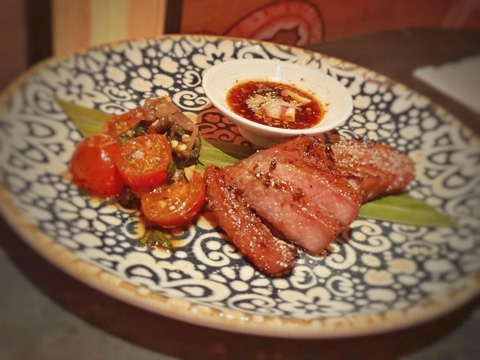 Isaan-style grilled pork with a tomato salad.