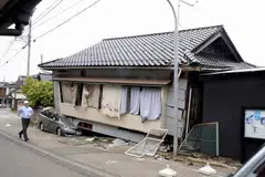 The collapsed first floor of a house and a car crushed in Suzu, Ishikawa Prefecture, due to a strong earthquake on Friday.