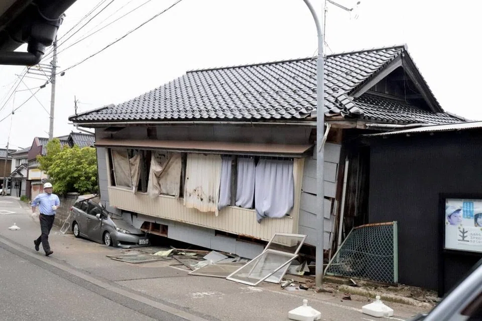 The collapsed first floor of a house and a car crushed in Suzu, Ishikawa Prefecture, due to a strong earthquake on Friday.