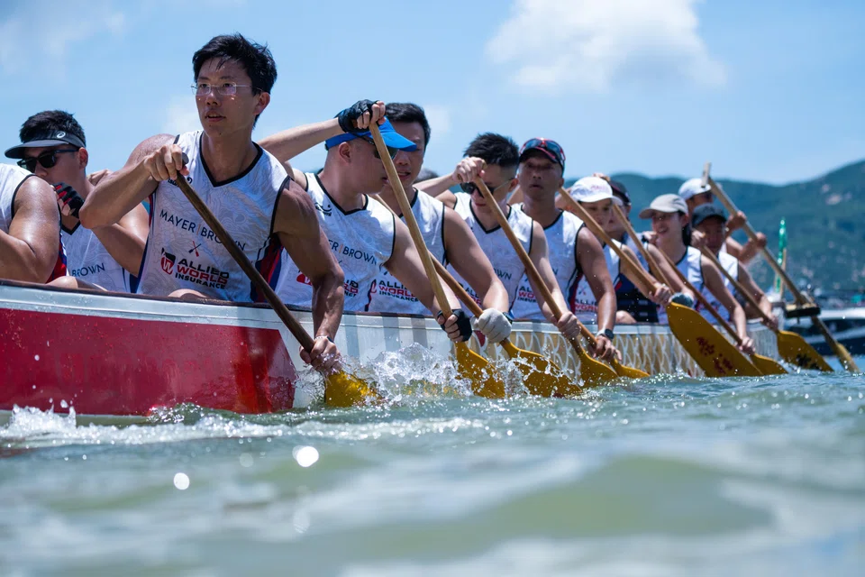 Under the scorching sun, 174 rowing teams competed aboard long boats topped by brightly coloured dragon heads.