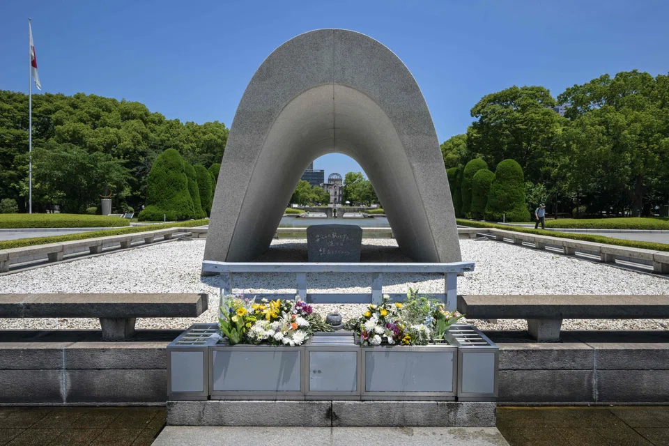 The Memorial Cenotaph at the Peace Memorial Park, with the Atomic Bomb Dome in the distance, in  Hiroshima, Japan.