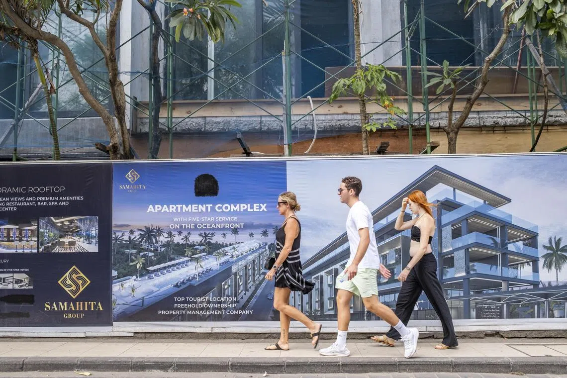 Tourists walk past a hotel under construction in Seminyak, Bali. The acting governor has proposed a moratorium on the construction of new hotels, villas, and nightclubs.