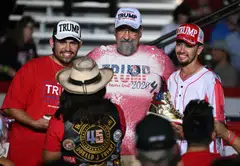 Attendees wear Trump apparel and hold his gold sneakers at the start of a campaign rally with former US President and Republican presidential candidate Donald Trump at the Expo World Market Center in Las Vegas, Nevada, Sept 13, 2024. 