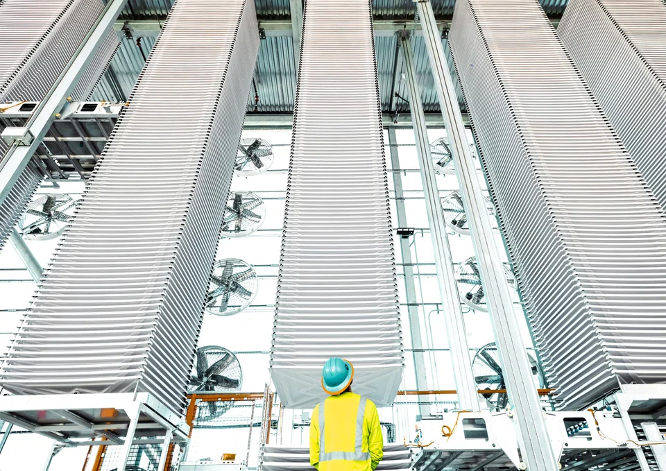 A worker looks at stacks of trays holding treated limestone, used to absorb CO2 form the air, at Heirloom's new plant in Tracy, California, US.