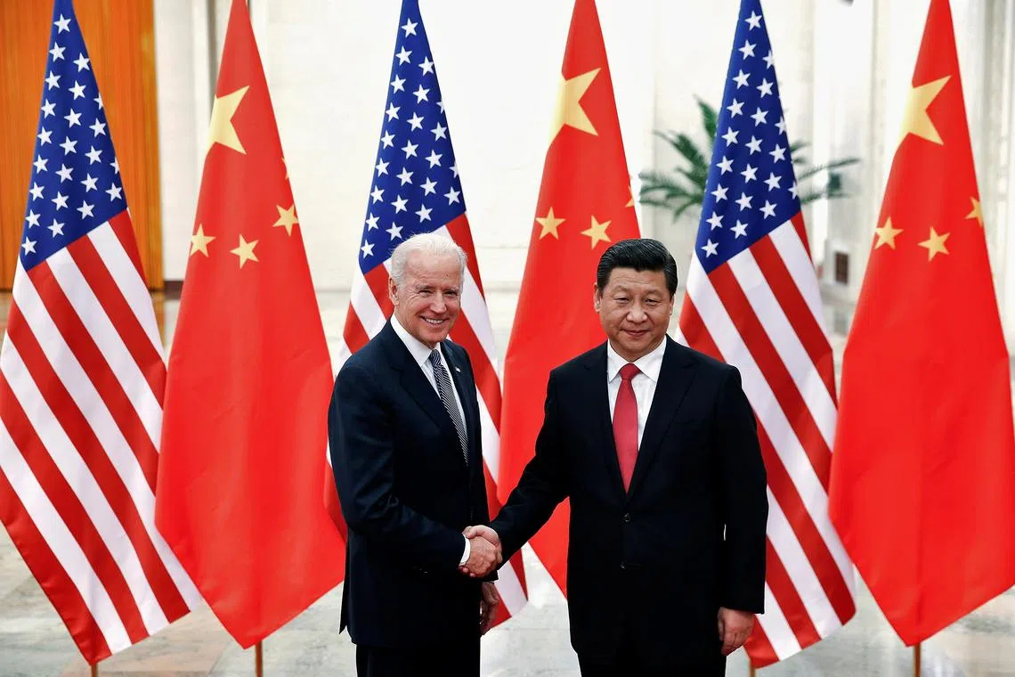 Chinese President Xi Jinping shakes hands with then US vice president Joe Biden in the Great Hall of the People in Beijing, December 4, 2013. 
