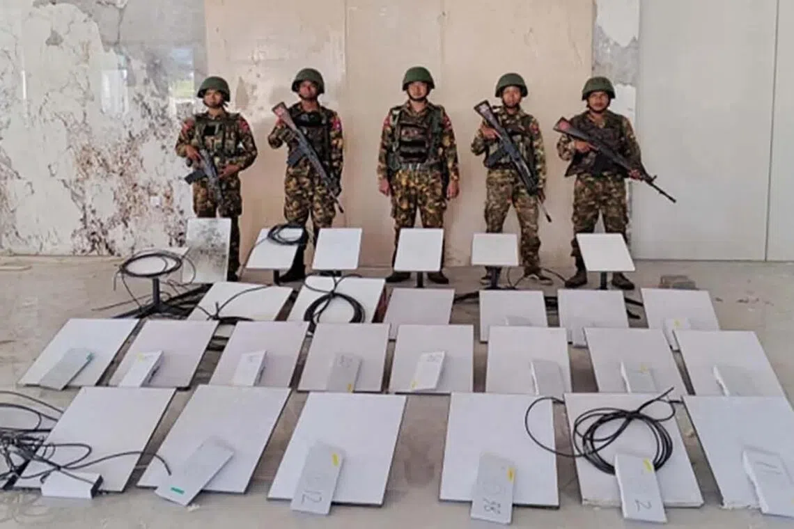 Members of Myanmar’s military standing next to Starlink devices seized during a raid on the KK Park online scam centre in Myawaddy, Myanmar on Oct 20.
