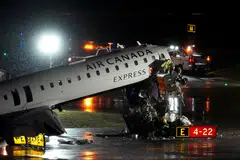 Debris hangs from a damaged Air Canada Express jet that collided with a fire truck at New York's LaGuardia Airport on Mar 23.
