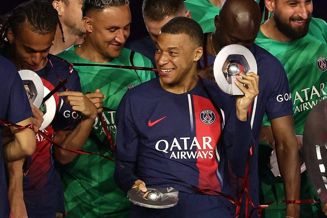 PSG French forward Kylian Mbappe celebrates after winning the French Ligue 1 championship following the match between PSG and Toulouse on May 12, 2024 at the Parc des Princes stadium in Paris, France.