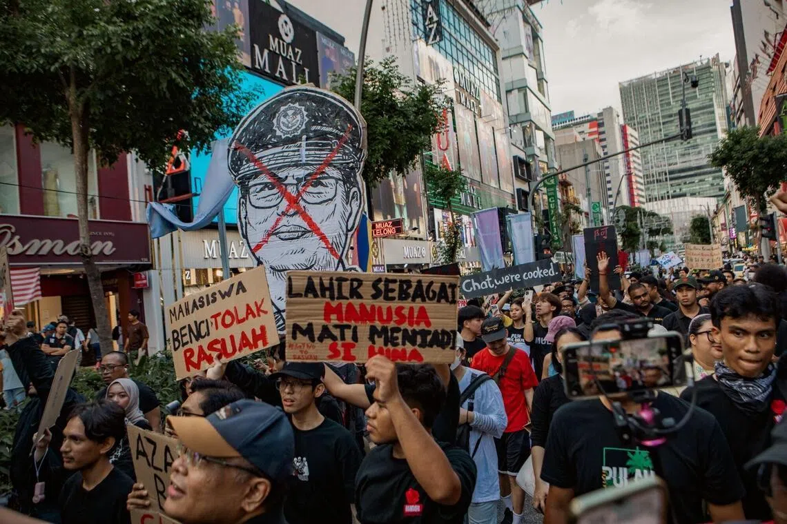 Protesters hold a poster of Malaysian Anti-Corruption Commission (MACC) Chief Commissioner Azam Baki during a demonstration in Kuala Lumpur, Malaysia, on Sunday, Feb. 15, 2026. Malaysias cabinet has ordered an investigation into the allegations surrounding anti-graft chief Azam, days after a report said he had shareholdings that were higher than allowed limits for public officials. Photographer: Samsul Said/Bloomberg