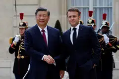 French President Emmanuel Macron shakes hands with President Xi Jinping as he arrives for a meeting at the Elysee Palace in Paris as part of the Chinese president's two-day state visit in France.