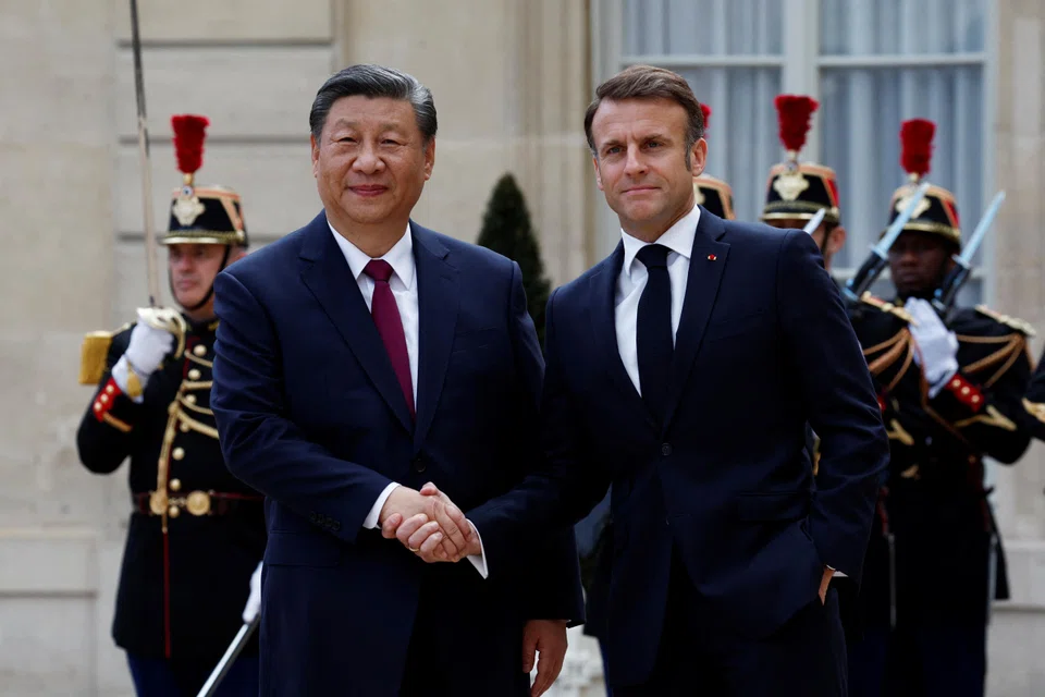 French President Emmanuel Macron shakes hands with President Xi Jinping as he arrives for a meeting at the Elysee Palace in Paris as part of the Chinese president's two-day state visit in France.