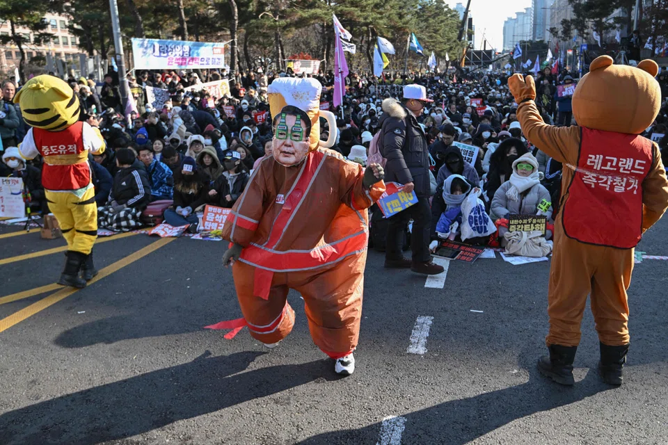 A man wearing a fat suit and a mask depicting South Korea's President Yoon Suk-yeol dances during a protest calling for Yoon's ouster outside the National Assembly in Seoul.