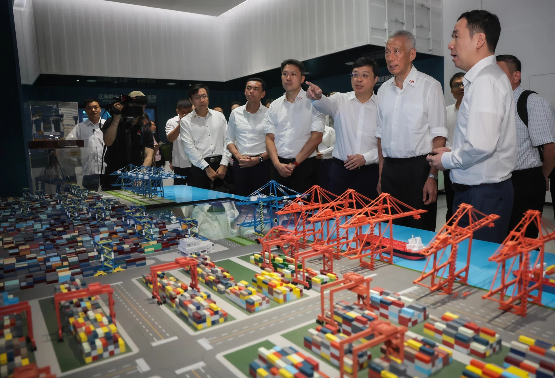 SM Lee Hsien Loong (second from right) is shown a model of an automated container terminal during his tour of the Beibu Gulf
