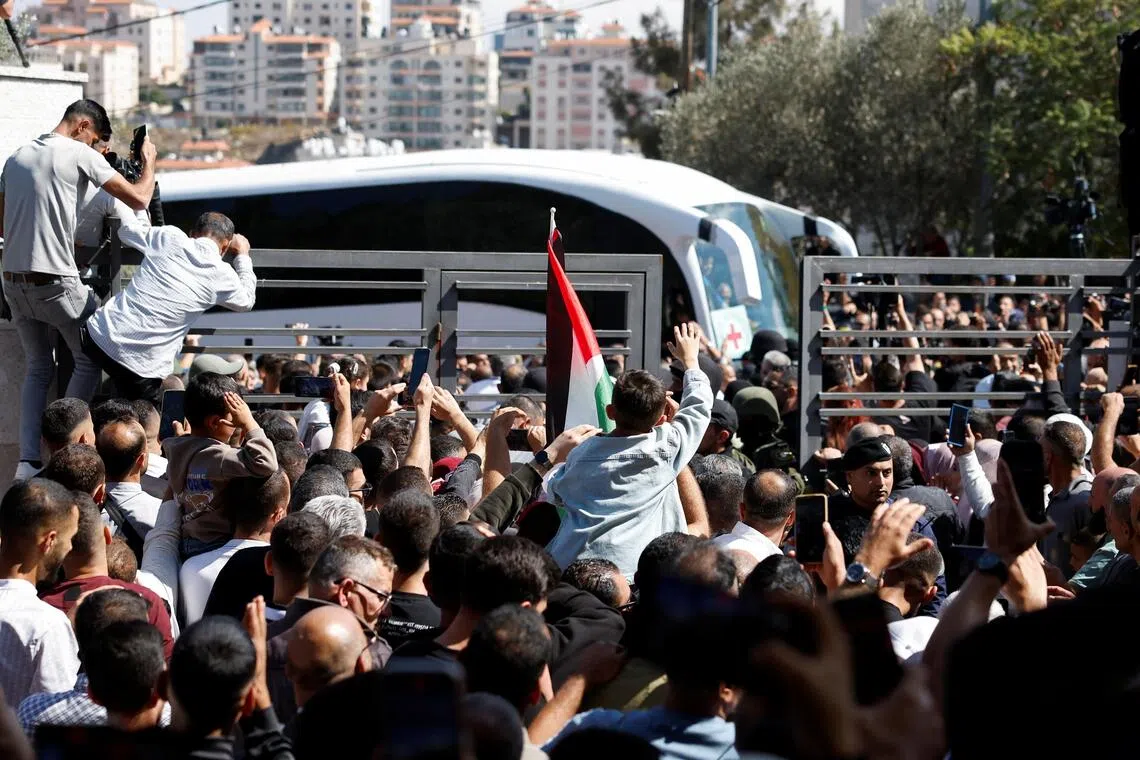 People gather to greet freed Palestinian prisoners as they arrive after being released from an Israeli jail as part of a hostages-prisoners swap and a ceasefire deal in Gaza between Hamas and Israel on Oct 13.