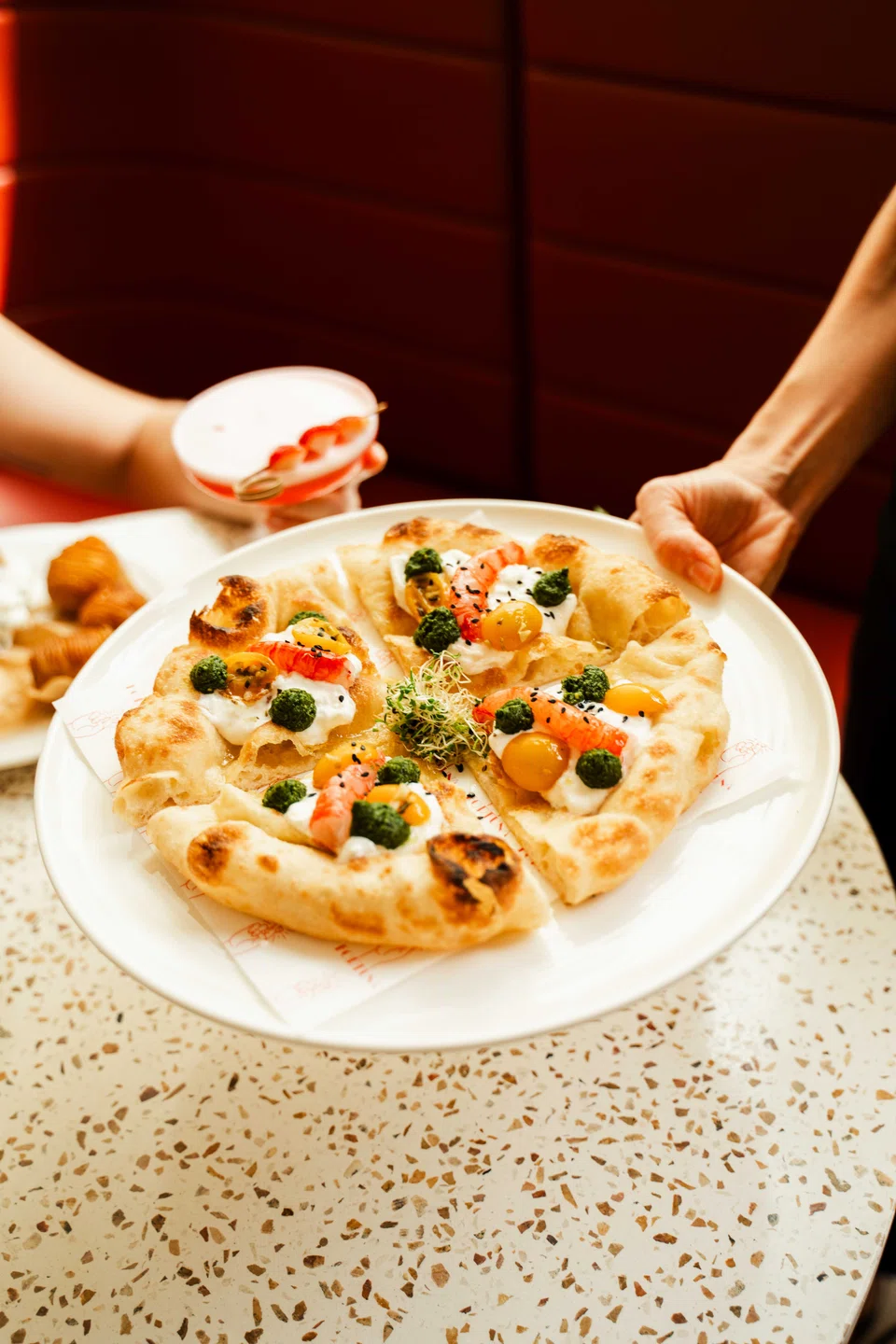 Gambero and stracciata pizza is lightly fried, then rebaked and topped with shrimp and pesto.
