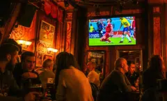 People watch a live broadcast of the World Cup match between Brazil and Serbia in a pub in Moscow. Russia was banned from taking part in the World Cup due to the country's invasion of Ukraine.