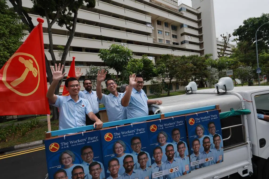 The Workers' Party's winning team for Aljunied GRC – (from left) Kenneth Tiong, Pritam Singh, Gerald Giam, Sylvia Lim (in background) and Fadli Fawzi – greeting residents on Sunday before a doorstop at Eunos Market.