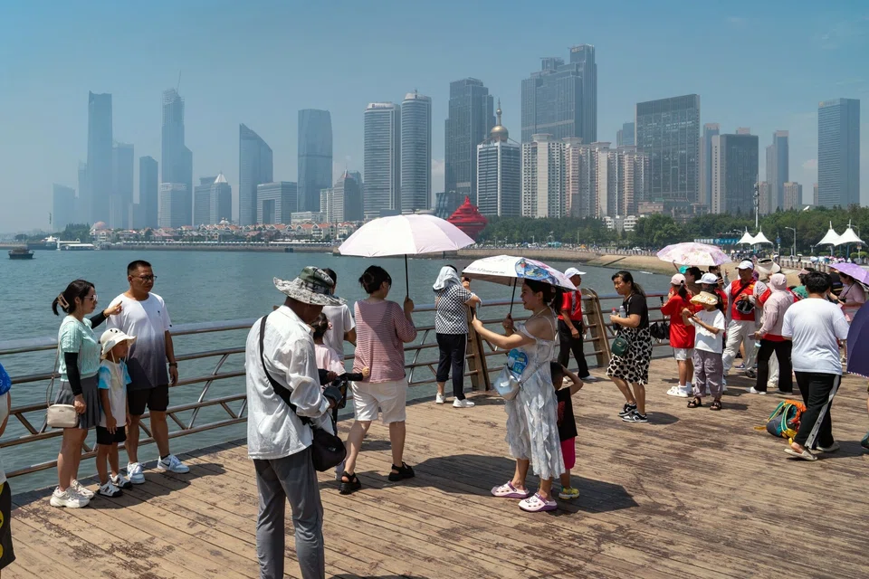 Pedestrians in Qingdao, China. Two-thirds of the global digital economy – will be powered by the US and China. 