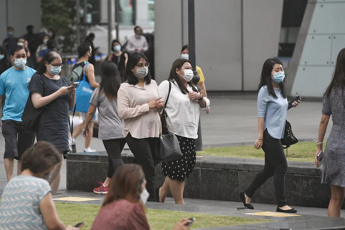 Office workers walking at Raffles Place after work in the evening on 8 March 2022.