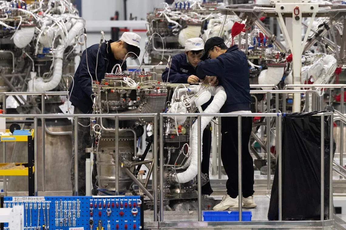 Engineers work on a rocket engine in Zhejiang, China. The expected global job deficit in 10 to 15 years' time is not only a development issue, but also an economic and national security challenge, says the writer.