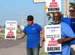 Workers hold signs during a walkout by members of the International Association of Machinists and Aerospace Workers (IAM) over contract negotiations, outside Boeing company's facility, Berkley, Missouri, Aug 4, 2025.