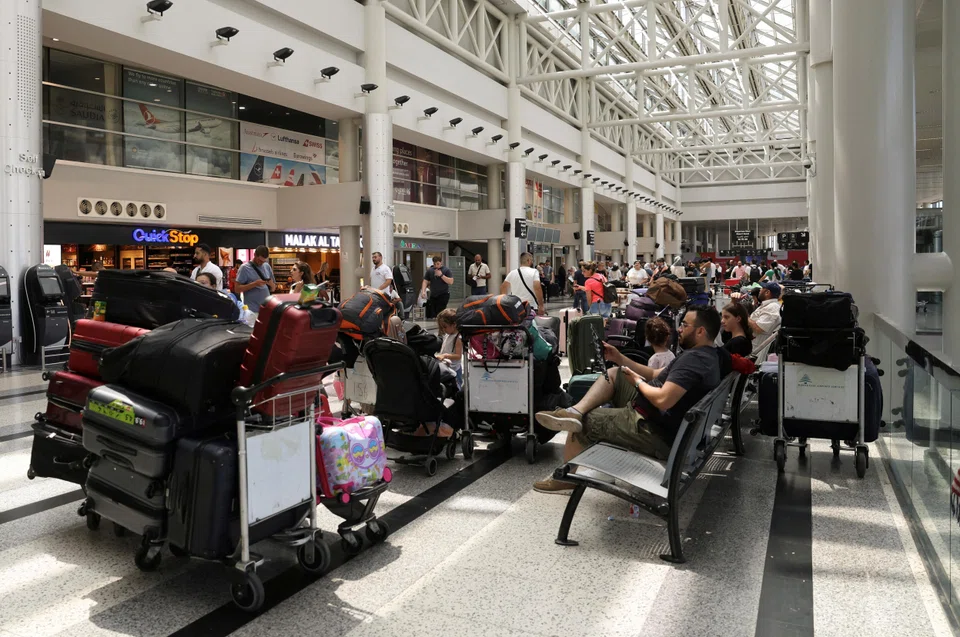 People sit near their luggage at the Beirut–Rafic Hariri International Airport,  Beirut, Lebanon, July 29, 2024. Embassies have repeatedly urged their citizens to leave Lebanon while commercial flights are still available.
