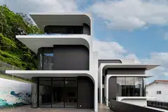 The house has a striking facade of tiered arches and curves.   