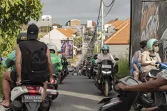 Motorcyclists travel on a street in Bali. Indonesia has a scheme to offer a 7 million rupiah discount to buyers of electric motorcycles.
