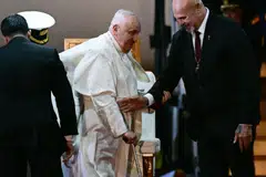 Pope Francis is helped by Papua New Guinea's Deputy Prime Minister John Rosso (R) as he takes part in a welcome ceremony upon arrival at the Port Moresby International airport on Sep 6, 2024. The pope is on the second stop of a marathon 12-day tour to the Asia-Pacific region. 