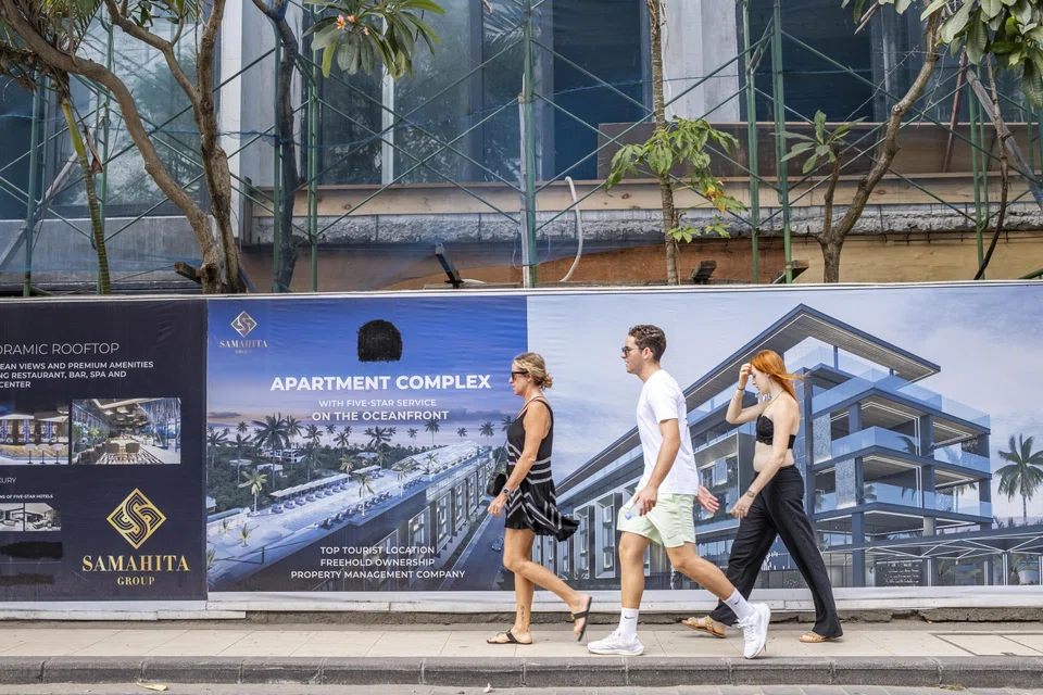 Tourists walk past a hotel under construction in Seminyak, Bali. The acting governor has proposed a moratorium on the construction of new hotels, villas and nightclubs.