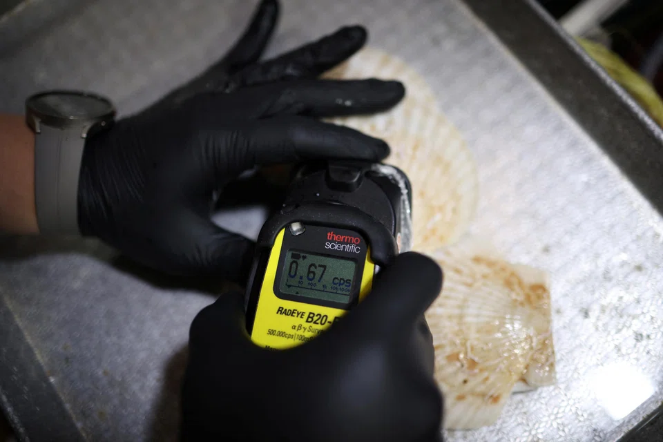 An official measuring radiation levels of scallops imported from Japan as they conduct a regular radioactivity check. Hong Kong and Macau will ban aquatic product imports from 10 Japanese regions including Tokyo and Fukushima.
