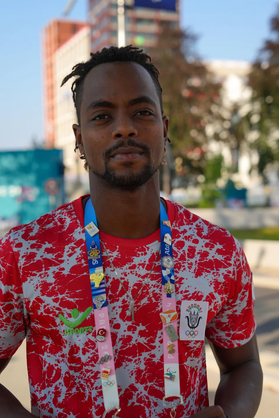 Swimmer Belly-Cresus Ganira from Burundi, shows off his trading pins. 