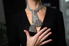 A woman wearing an 18th century diamond jewel necklace composed of three rows of diamonds finished with a diamond tassel at each, weighing approximately 300 carats, at a press preview at Sotheby's in Geneva, Switzerland, Nov 7, 2024. 