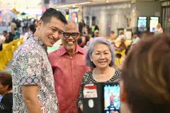 (From left) Former chief of army David Neo and Social and Family Development Minister Masagos Zulkifli posing for photos with a resident at Our Tampines Hub on April 12.