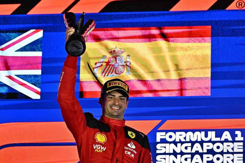 Ferrari's Spanish driver Carlos Sainz Jr celebrating on the podium after winning the Singapore Formula One Grand Prix.
